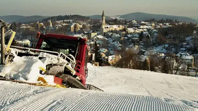Blick über die frisch präparierte Piste mit Pistenbulli in der Ski Arena Eibenstock