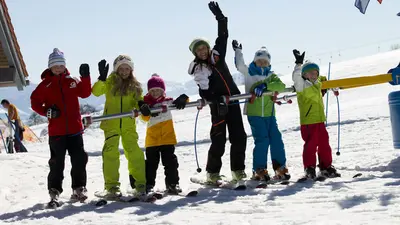 Kinder mit der Skilehrerin in der Skischule