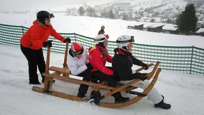 Rodler auf einem Riesenschlitten am Schießberg