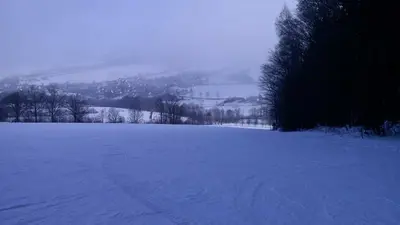 Blick über die abendliche Piste ins Tal in Königswalde