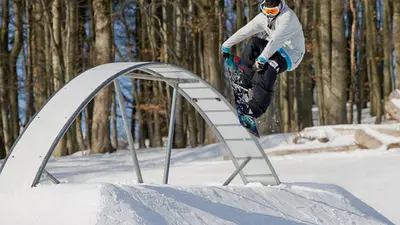 Snowboarder auf einem Hindernis im Snowpark
