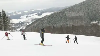 Skifahrer auf der Piste im Skigebiet Hohe Lied mit Blick ins Tal