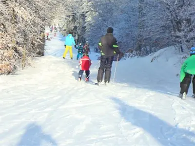 Familie bei der Abfahrt auf der blauen Piste in der Wintersport Arena © wintersport-arena.com