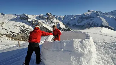 Zwei Wintersportler bauen ein Iglu in Engelberg