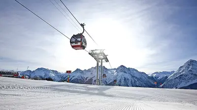 Blick auf Piste und Gondelbahn von Motta Naluns