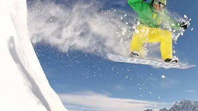 Snowboarder beim Sprung auf der Piste in Savognin