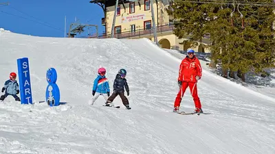 Kinder mit Skilehrer auf der Piste in Rigi