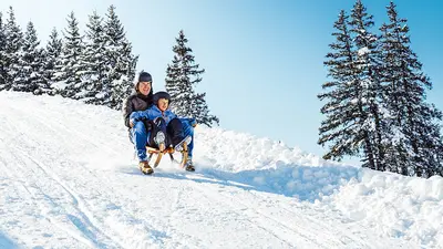 Vater und Sohn auf der Rodelbahn im Skigebiet Wildhaus