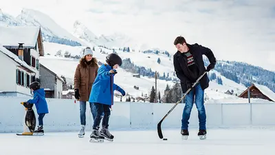 Familie beim Eislaufen und Eishockeyspiel in Wildhaus