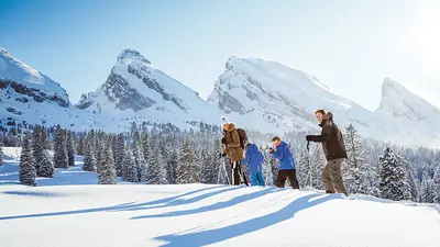 Familie beim Schneeschuhwandern im Skigebiet Wildhaus