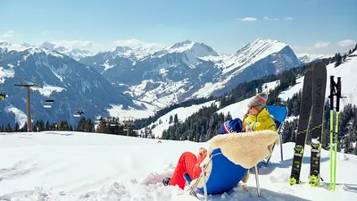 Skifahrer machen Pause in Liegestühlen am Diedamskopf