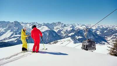 Skifahrer vor einer Gondel im Skigebiet Diedamskopf