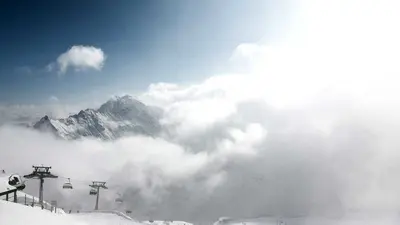 Blick ins wolkenverhangene Tal und auf die Sesselbahn der Gargellen