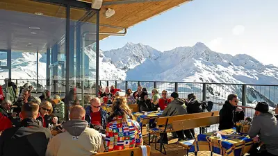 Menschen bei der Einkehr auf einer Sonnenterrasse am Sonnenkopf