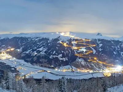 Panoramablick auf Bramberg am Abend mit den beleuchteten Pisten © Wildkogel-Arena Neukirchen & Bramberg