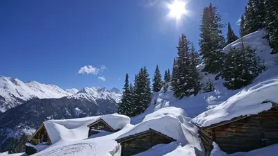Verschneite Hütten bei Sonnenschein