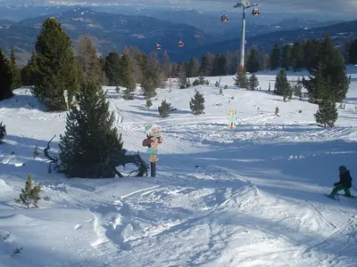 Blick auf eine Piste mit Maskottchen Bam-Bam und Barney Ger&ouml;llheimer im Yabaadabbadoo-Land am Kreischberg © Schneehoehen.de