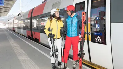 Paar auf dem Weg mit dem Zug ins Skigebiet