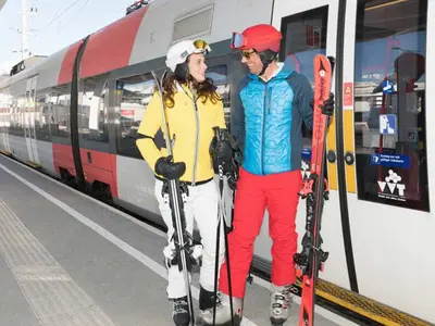 Paar auf dem Weg mit dem Zug ins Skigebiet © Region Seefeld / Stefan Wolf