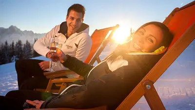 Paar trinkt Sekt in Liegestühlen im Skigebiet Lienzer Bergbahnen