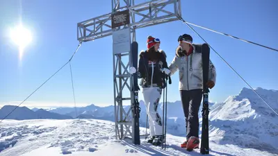 Skifahrer am Gipfelkreuz in Sportgastein
