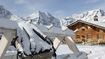 Rucksack am Skiständer vor einer Hütte
