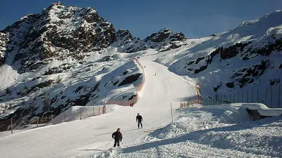Zwei Skifahrer auf einer ins Tal führenden Piste in Aprica