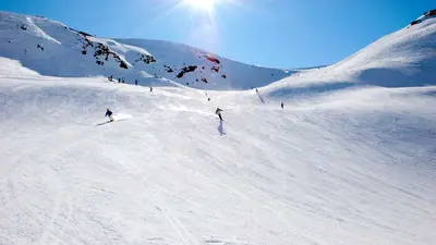 Skifahrer fahren auf breiter Piste am Speikboden
