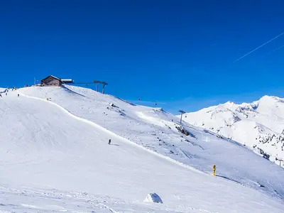 Skifahrer auf Piste am Speikboden mit Hütte im Hintergrund © Speikboden AG