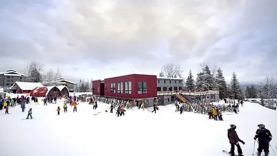 Blick auf Wintersportler vor der Talstation des Red Mountain Resorts