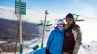 Ein junges Paar mitten im Skigebiet