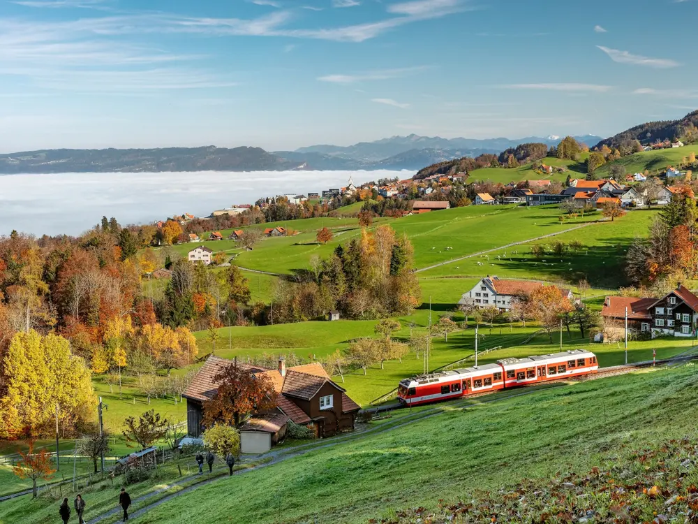 Das Bild zeigt Heiden und Wolfhalden samt Appenzeller Bahnen im herbstlichen Kleid oberhalb der Nebelgrenze.