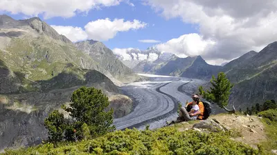 Paar bei einer Wanderpause mit Blick über den Aletschgletscher