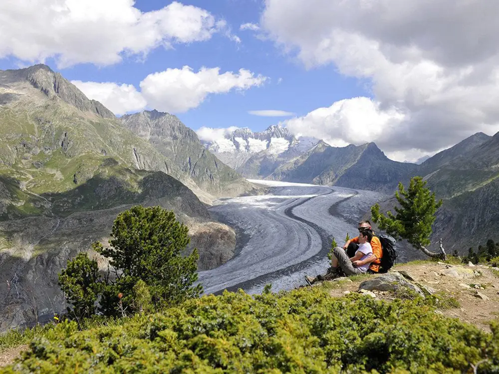 Paar bei einer Wanderpause mit Blick über den Aletschgletscher