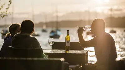 Besucher bei einer Weinprobe am See bei Murten