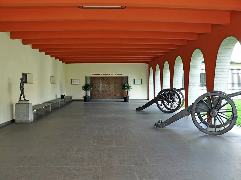 Von Kanonen gesäumter Arkadengang zum Eingang des Bundesbriefmuseums in Schwyz