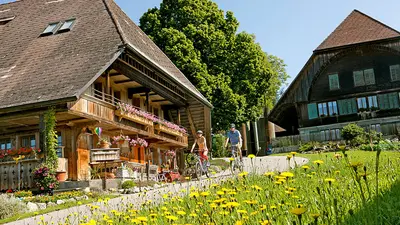 E-Biker vor Bauernhäusern in Luetzelfluh im Emmental