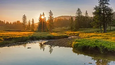 Sonnenaufgang an einem Moorsee, im Hintergrund der Glaubenbergpass im Entlebuch