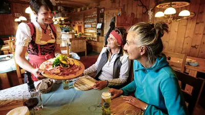 Wanderer bei einer Brotzeit auf der Tulfer Hütte