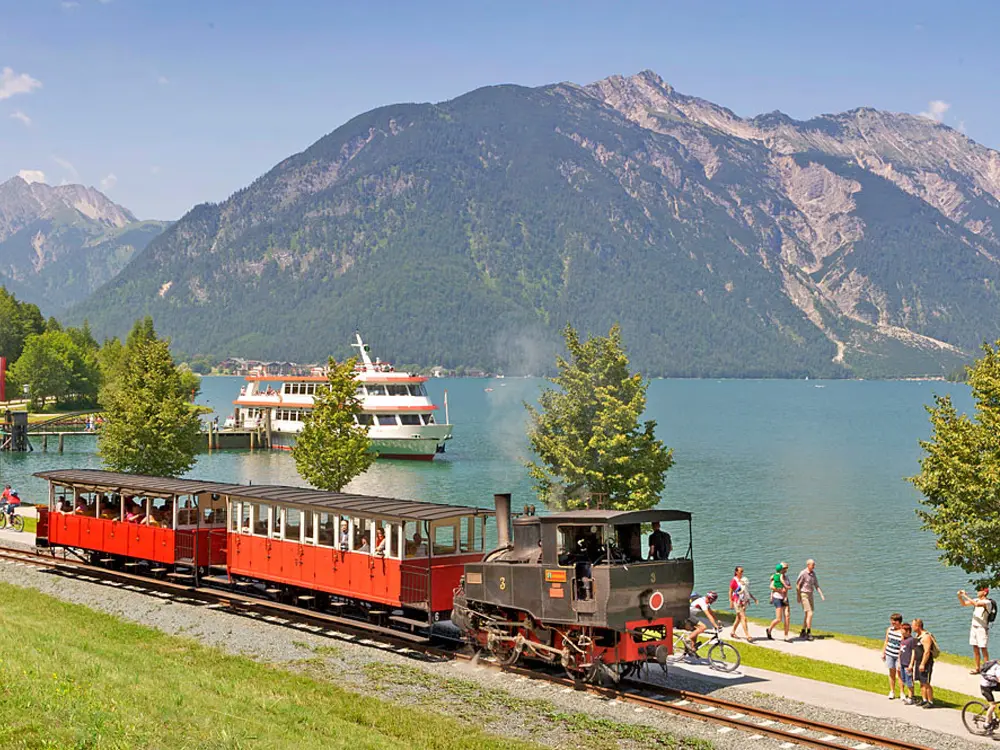 Blick auf den Achensee, die Dampfbahn und einen Ausflugsdampfer