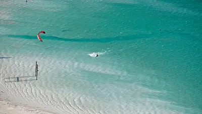 Luftaufnahme des Badestrands Buchau mit Badegästen und Kitesurfer am Achensee
