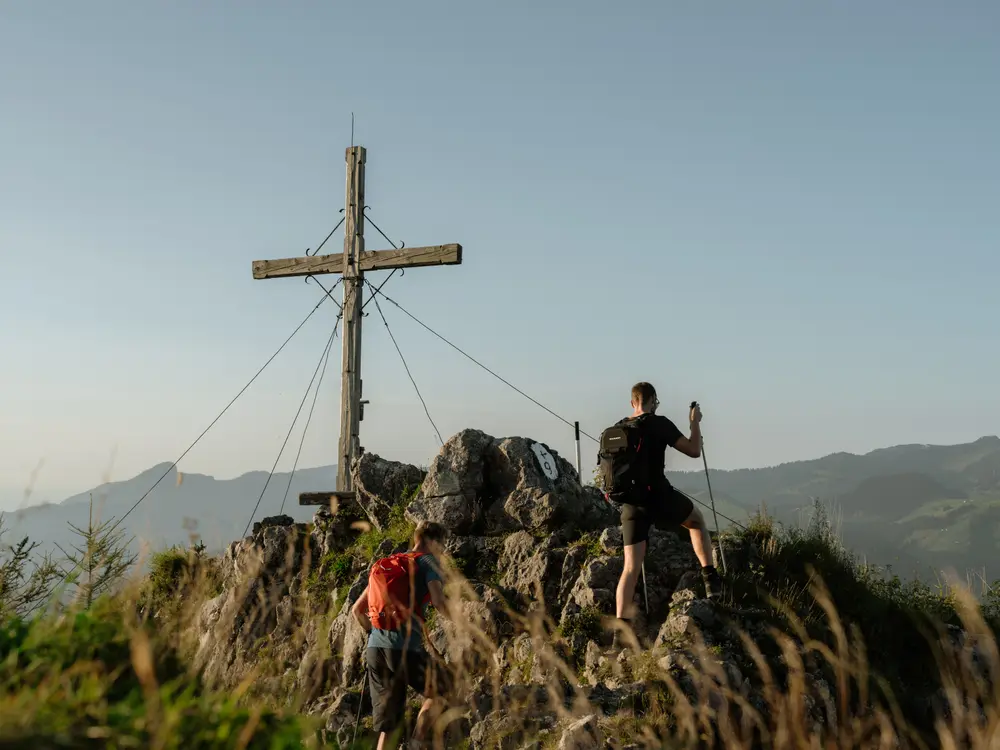 Wanderer bei der Ankunft am Gipfelkreuz
