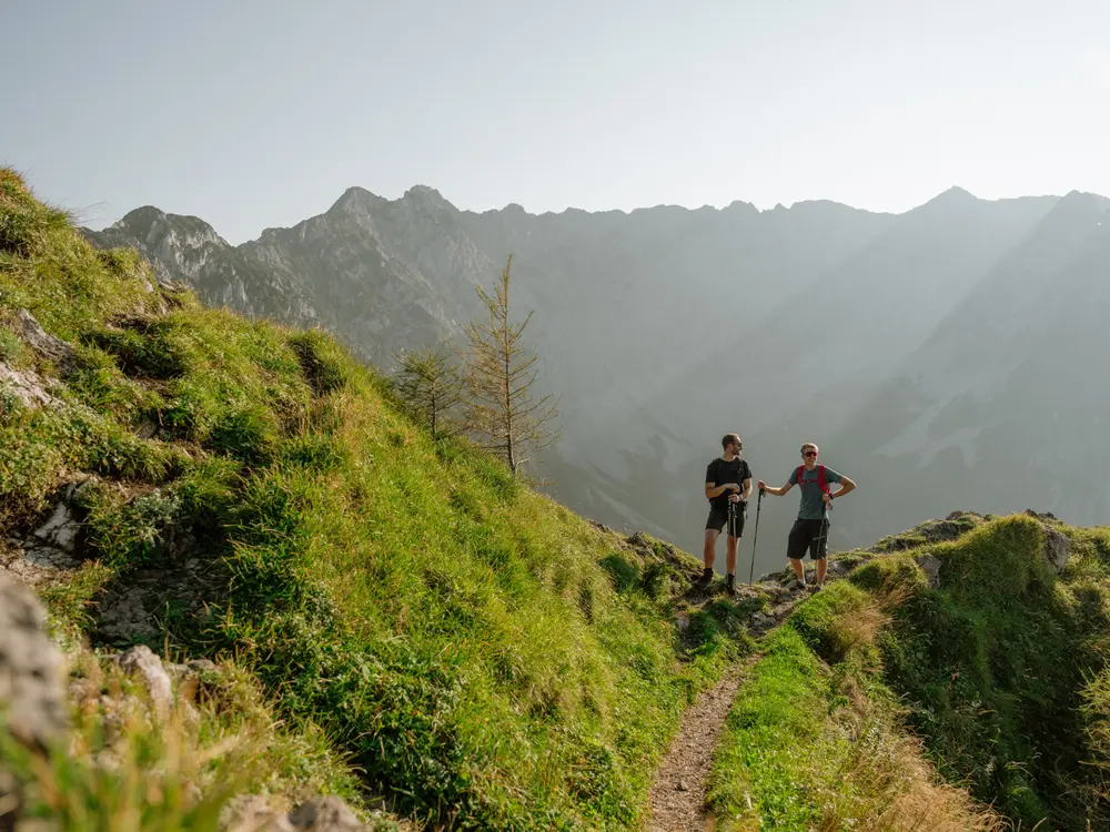 Wanderer auf einem kleinen Bergpfad im Kaiserwinkl