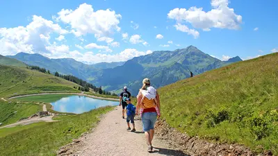 Familie wandert zu einem Teich am Schatzberg