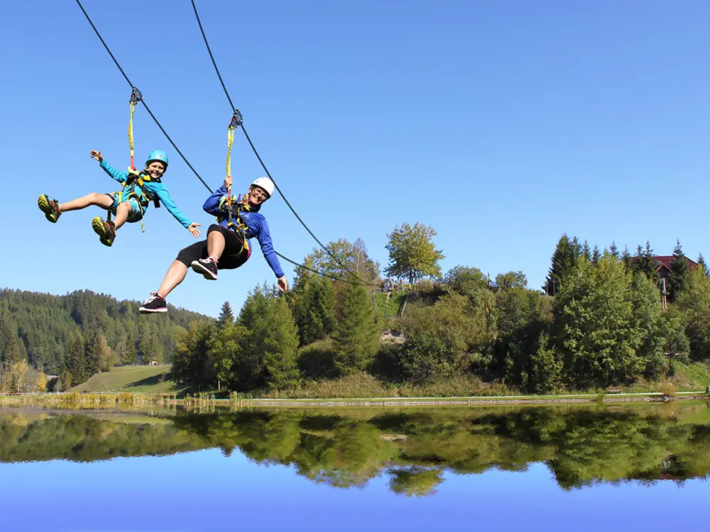 Besucher auf der Seilrutsche im Outdoorparc Lungau