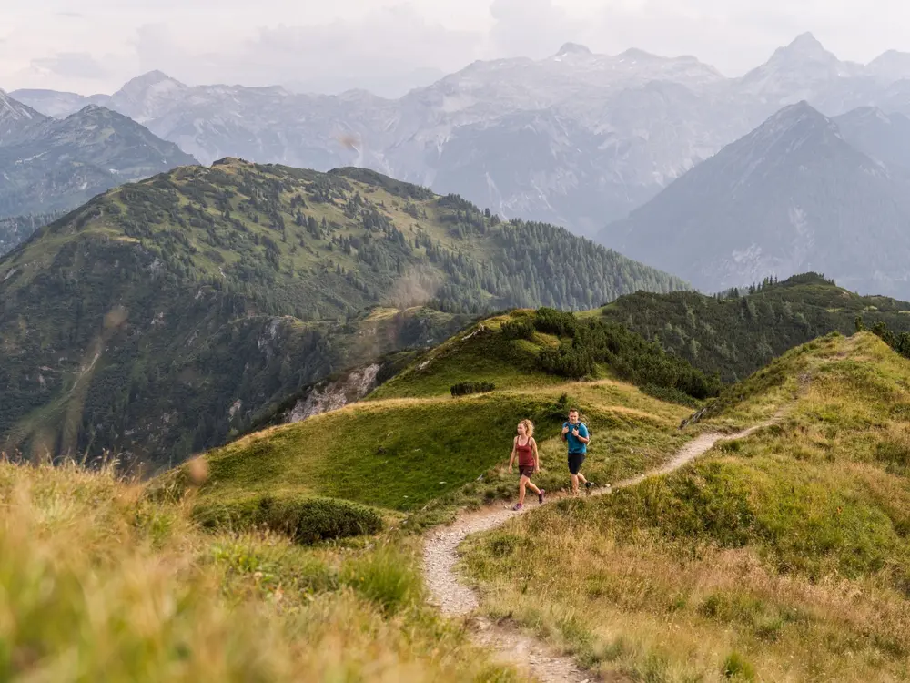 Ein paar wandert auf den Lackenkogel beim Gipfelspiel in Altenmarkt-Zauchensee