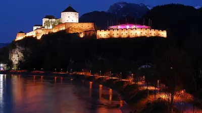 Blick auf den Inn und die beleuchtete Festung Kufstein bei Nacht