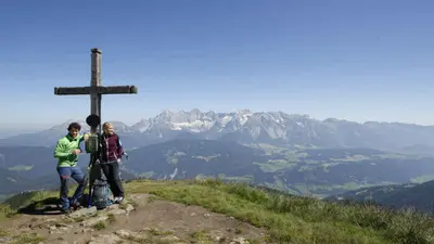 Paar am Gipfelkreuz der Gasselhöhe bei guter Fernsicht