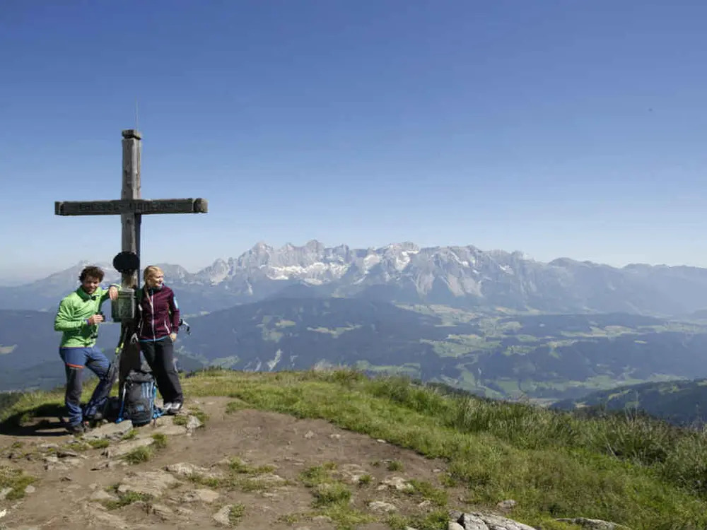 Paar am Gipfelkreuz der Gasselhöhe bei guter Fernsicht