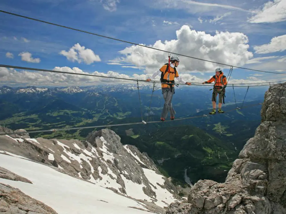 Paar bei traumhaftem Wetter und guter Fernsicht auf einem Klettersteig 
